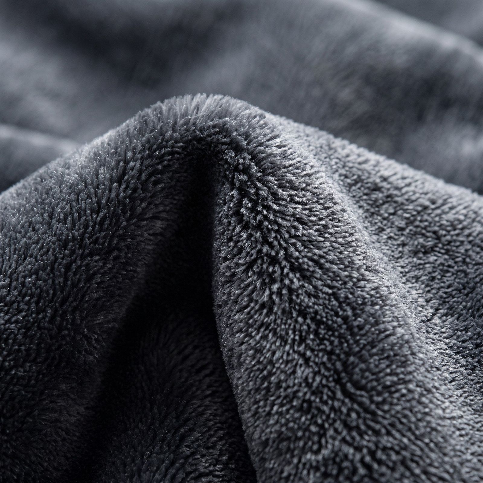 Illustrated close-up of charcoal plush blanket texture.