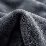 Illustrated close-up of charcoal plush blanket texture.